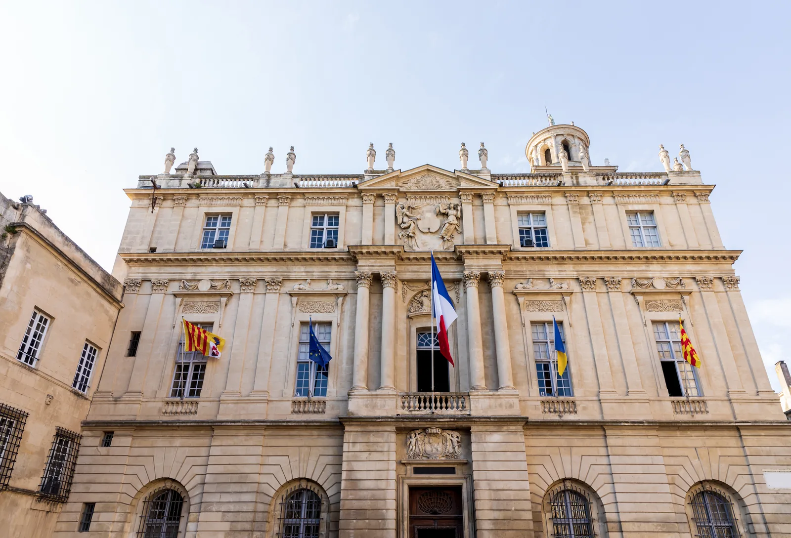 Crédit : la façade d'un hôtel de ville, drapeaux au vent