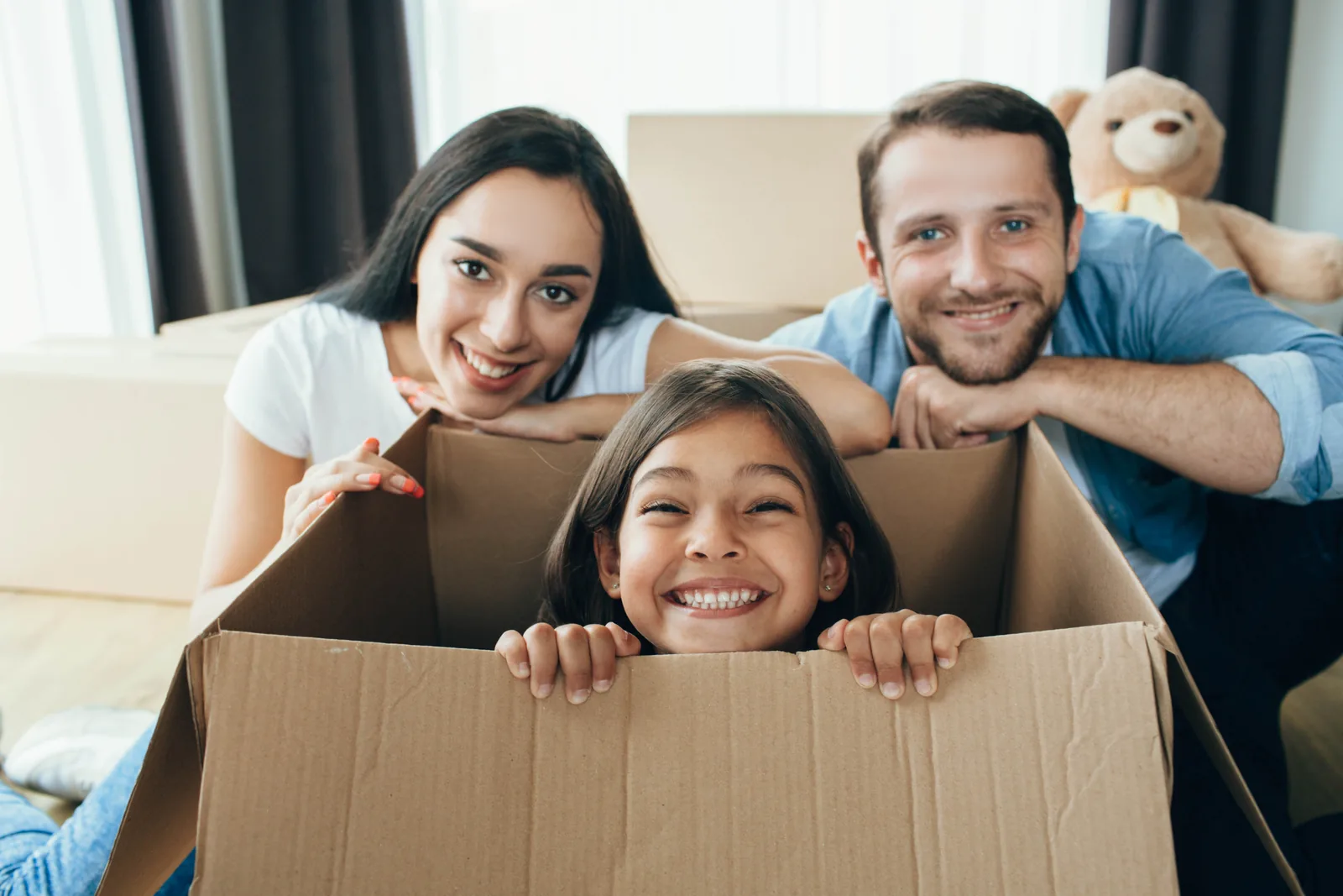 Une famille souriante au milieu de ses cartons d'emménagement