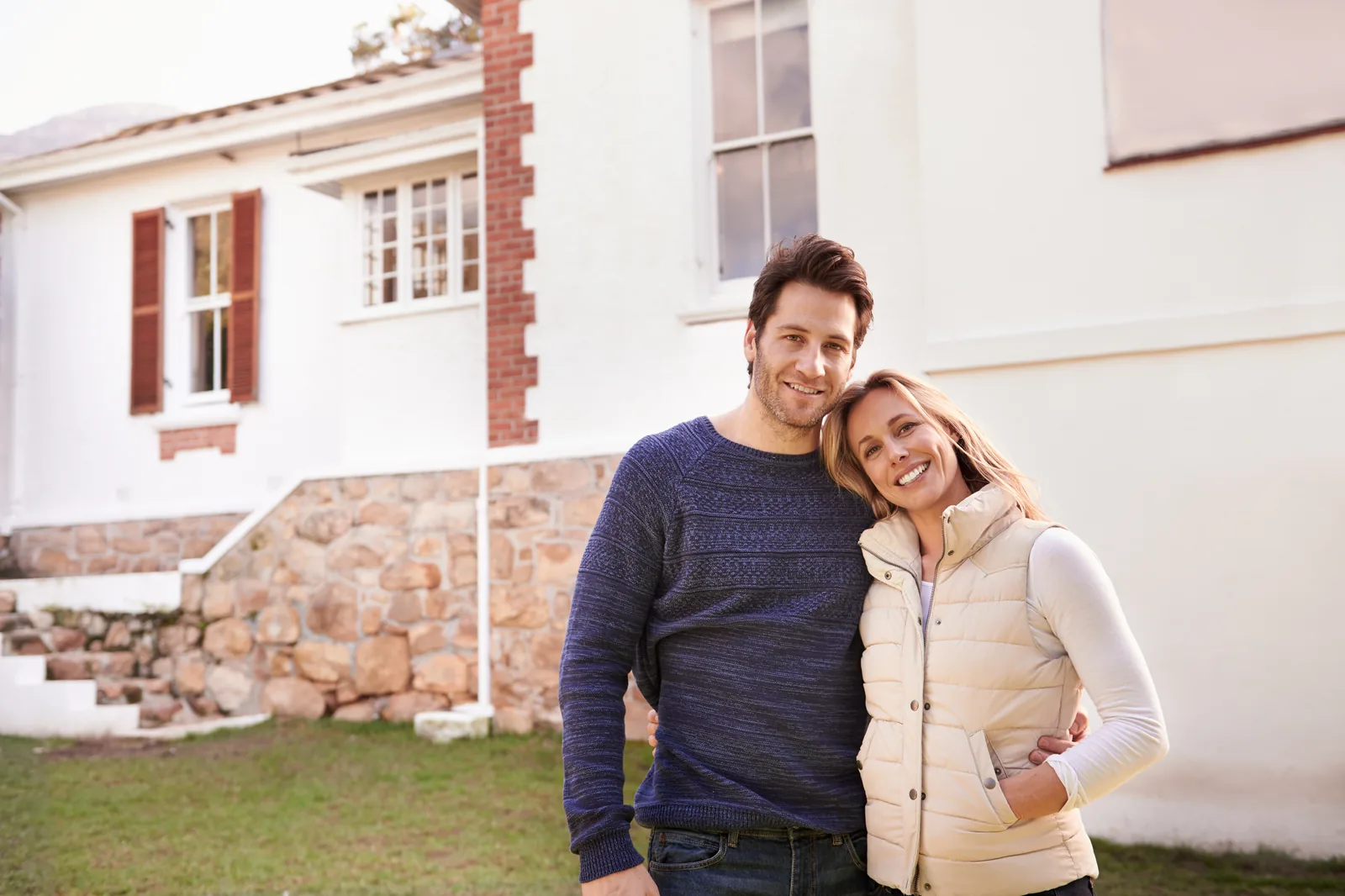 Rachat de crédit et hypothèque : un couple devant la maison qu'il vient d'acheter
