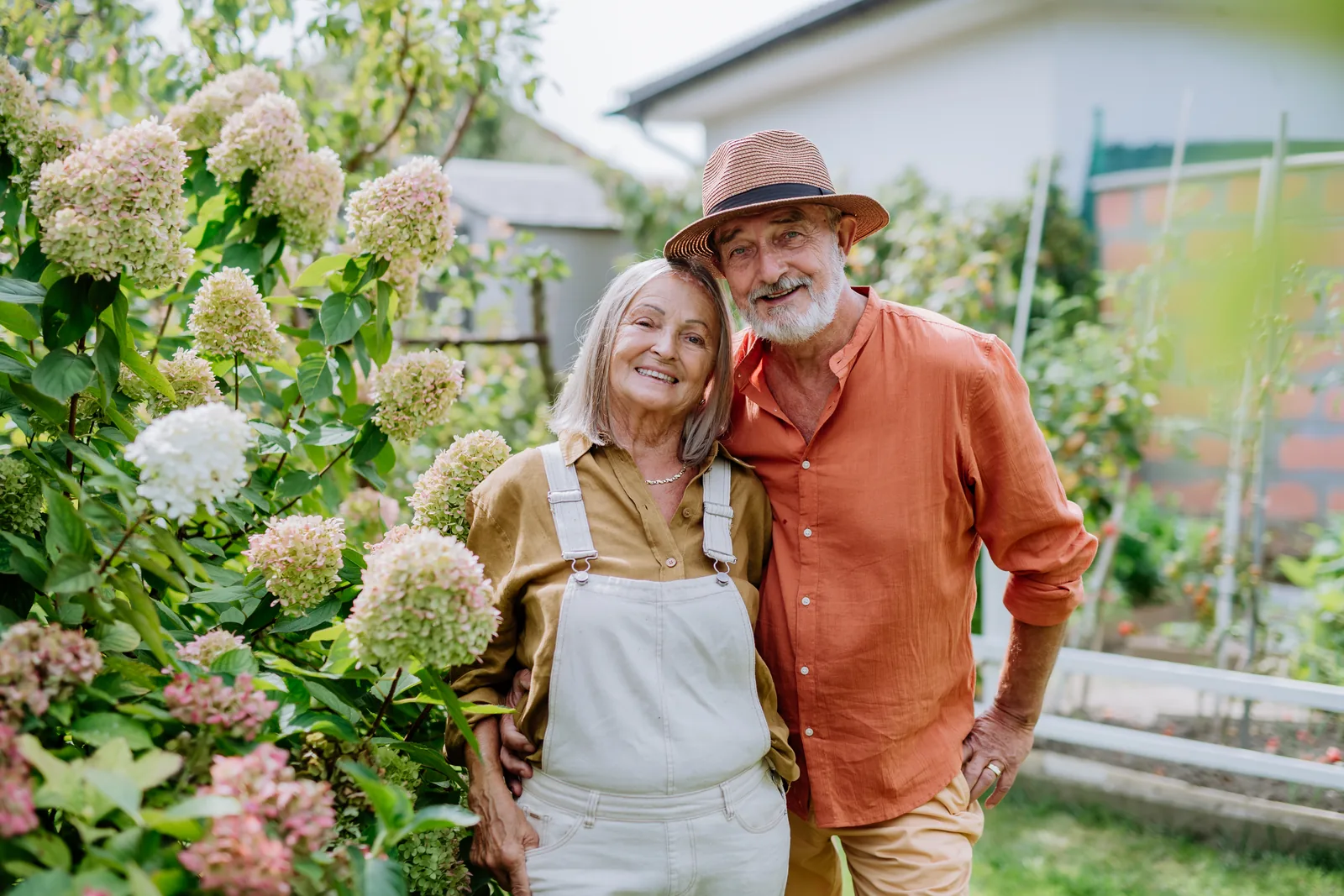 Taeg rachat de crédit : un couple de retraités souriants dans son jardin